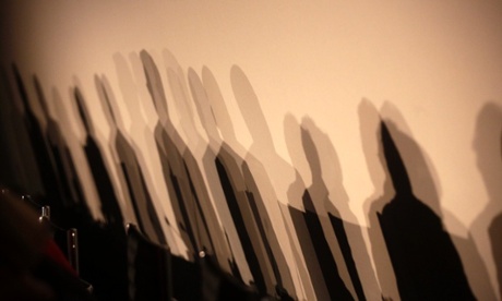 Shadows of members of a panel are seen on a wall before a meeting about the 