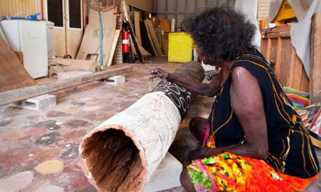 Aboriginal artist painting onto a story pole