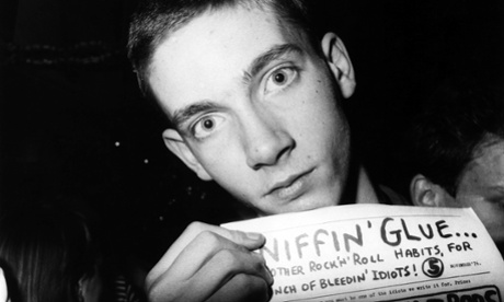 A punk holding up a copy of Sniffin' Glue.
