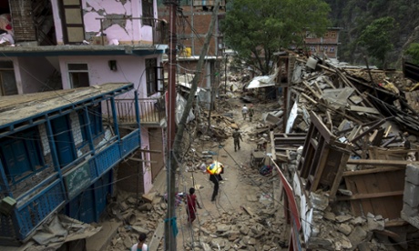 People walk past collapsed buildings after the earthquake in Dolakha, Nepal.