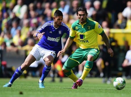 Norwich's Bradley Johnson evades Kevin Bru of Ipswich Town.