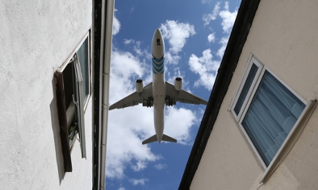 A passenger jet comes into land over houses next to Heathrow airport.
