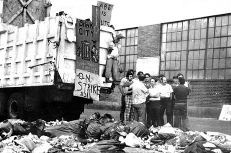 Striking New York garbagemen stand by signs reading “Stink City” AND “Abe is nuts”.