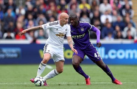 Jonjo Shelveyholds off Yaya Toure.
