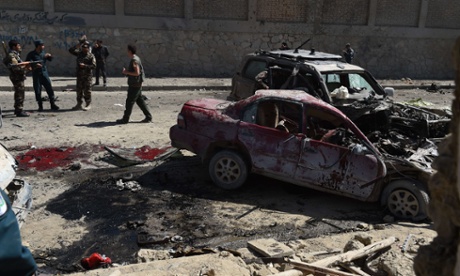 Afghan and foreign security forces inspect the site of the suicide attack near Kabul airport.