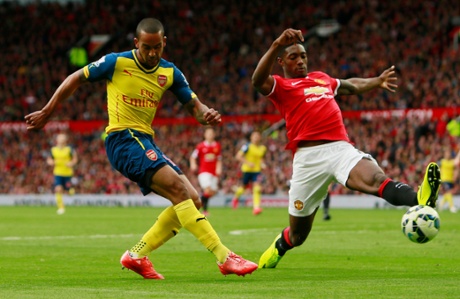 Theo Walcott hits a cross which is deflected off  Manchester United's Tyler Blackett to score an own goal and the first for Arsenal.