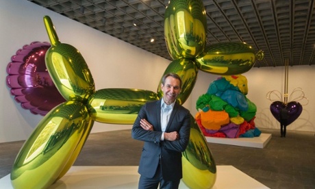 Artist Jeff Koons poses in front of his Balloon Dog (Yellow).