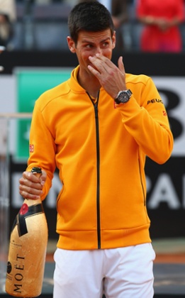 Novak Djokovic reacts after the champagne cork hit him in the face.