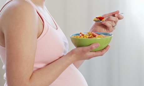 A pregnant woman eats cereal