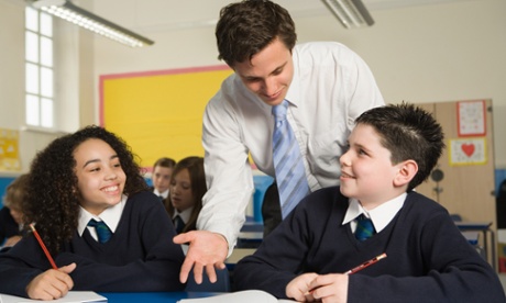 Teacher talking to boy in classroom 