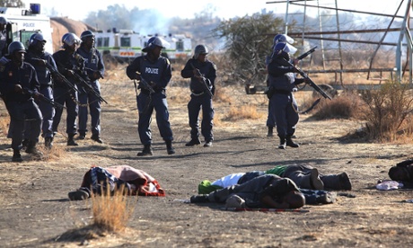 Police officers with the bodies of dead strikers after the shootings.