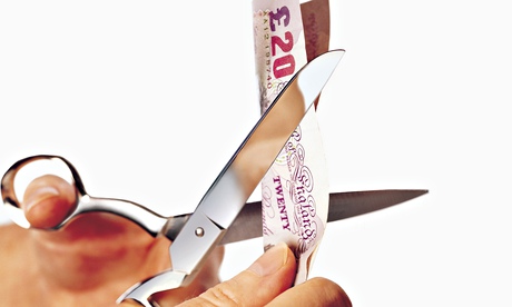 Scissors cutting a £20 note