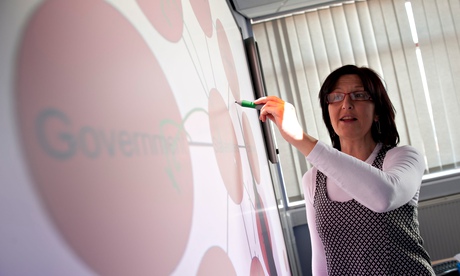 A woman doing a powerpoint presentation on a interactive  touch screen whiteboard
