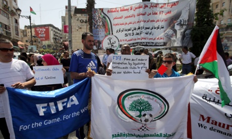 Palestinians hold banners as they demonstrate in Ramallah, demanding the expulsion of Israel from Fifa.