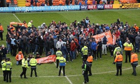 Blackpool's fans invade the pitch during a protest in the game against Huddersfield Town.