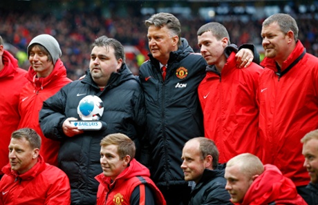The Manchester United boss Louis van Gaal poses with the Old Trafford and their trophy.