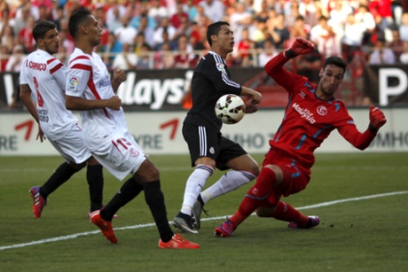 Sevilla's goalkeeper Sergio Rico stops a shot from Real Madrid's Cristiano Ronaldo.