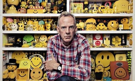norman cook in front of shelves full of smiley faces
