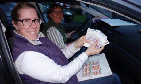 Two women show off their winnings after playing drive-in bingo in Sweden
