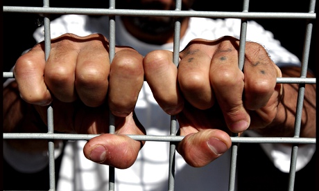 Prisoners hands on a wire fence