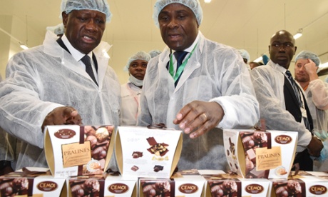 President of the Ivory Coast Alassane Ouattara (left) listens to Benjamain Bessie, the director general of the Cémoi Ivory Coast factory as he explains the production of chocolate.