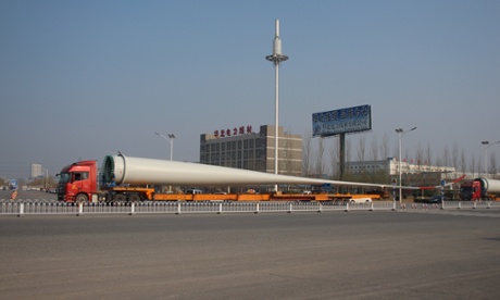 A wind turbine blade is loaded on to a flatbed truck.