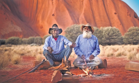 Two men sitting by a fire at Uluru