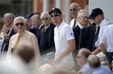 England captain Alastair Cook walks through the members as he leads his team out to field.