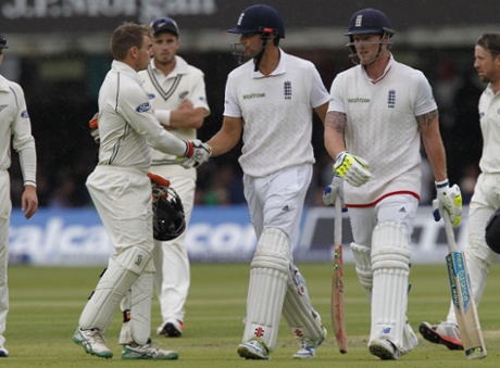 Englands captain Alastair Cook is congratulated by New Zealands wicketkeeper Tom Latham as rain stops play.