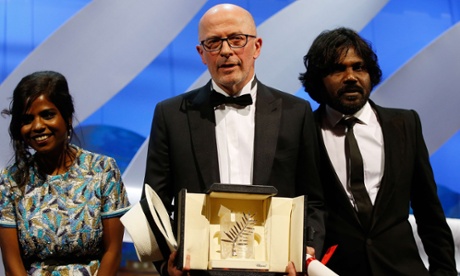 French director Jacques Audiard poses on stage with Sri Lankan actress Kalieaswari Srinivasan (L) and Sri Lankan actor Jesuthasan Antonythasan after being awarded with the Palme d'Or for his film 