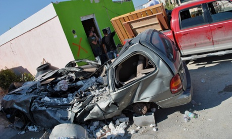 A completely crushed car in front of a house