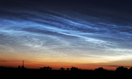 Blue wisps of cloud shine in the twilight sky.