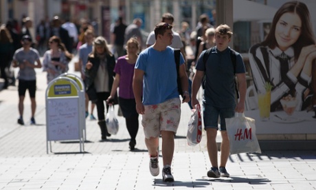 Shoppers walk past shops on the main shopping street in Bristol, England. Consumer confidence is at 2006 levels.