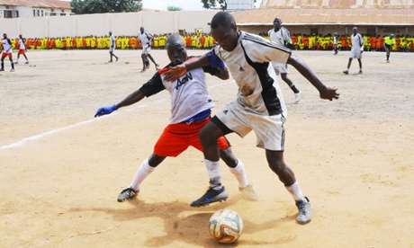 Manchester United play Liverpool on a pitch surrounded by watching prison inmates.
