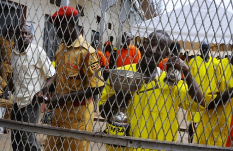 One of the Luzira prison inmates holds the Radio Simba football tournament trophy won by Manchester United.