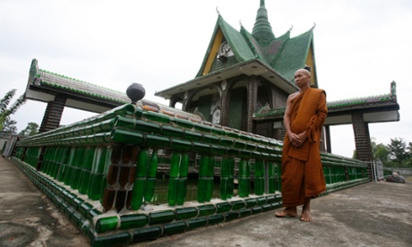 A Buddhist monk walks past the Wat Pa Maha Chedi Kaew temple, built with more than a million glass bottles, in Thailand's Sisaket province