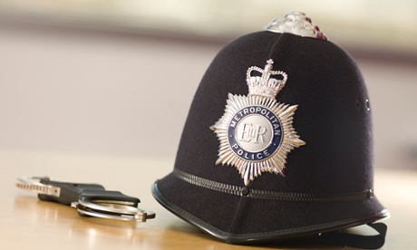 Police helmet and cuffs on a table.
