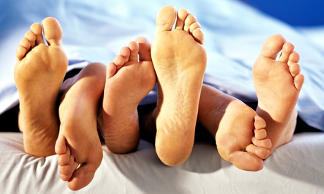 feet of three people lying in bed together