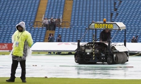 Water is cleared from the pitch as rain falls before play on the first day of the second Test match between England and New Zealand at Headingley.