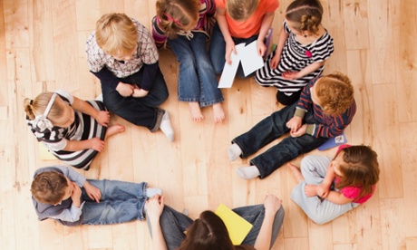 Children (2-3, 4-5) sitting in circle around teacher, directly above