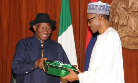 Outgoing Nigerian President Goodluck Jonathan (left) presents a gift to President-elect Muhammadu Buhari (right) in Abuja, Nigeria.