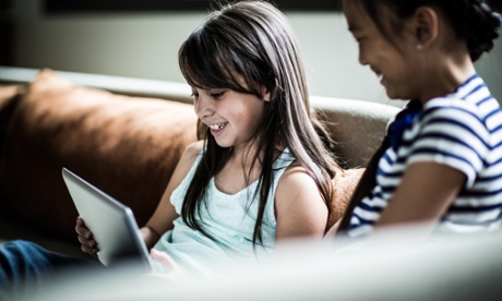 girls using tablet on couch