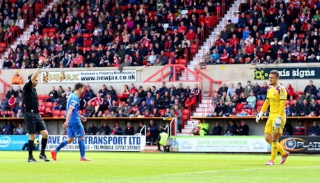 Referee Dean Whitestone shows Swindon Town goalkeeper Tyrell Belford a straight red card for conceding a penalty.