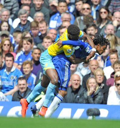 Juan Cuadrado and Wilfried Zaha battle for the ball.
