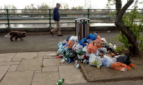 Litter piled by an overflowing bin along the Thames in west London