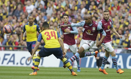 Aston Villa's Fabian Delph passes the ball despite the challenge of Arsenal's Francis Coquelin.