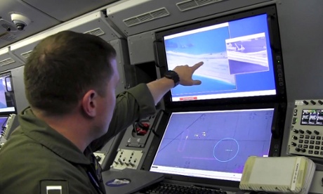 A US navy crewman aboard a surveillance aircraft views a computer screen purportedly showing Chinese construction on the reclaimed land of Fiery Cross Reef.