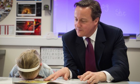 Prime Minister David Cameron helps with a reading lesson at the Sacred Heart Roman Catholic Primary School in Westhoughton