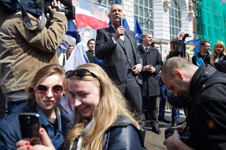 Audience members take a selfie while Janusz Korwin-Mikke gives a campaign speech to supporters in Gdańsk, Poland.