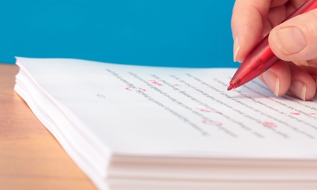 proofreader marking a document with red pen